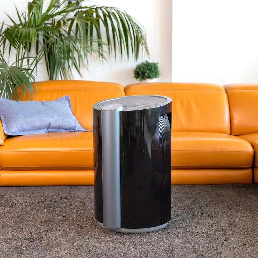 El Cecotec BigDry 9000 en un salón, delante de un sofá naranja